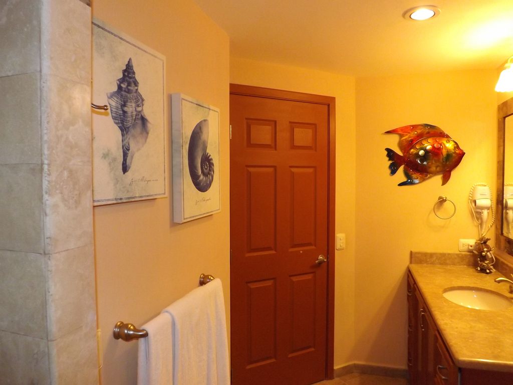 The spacious bathroom is decorated with beautiful sea-inspired artwork